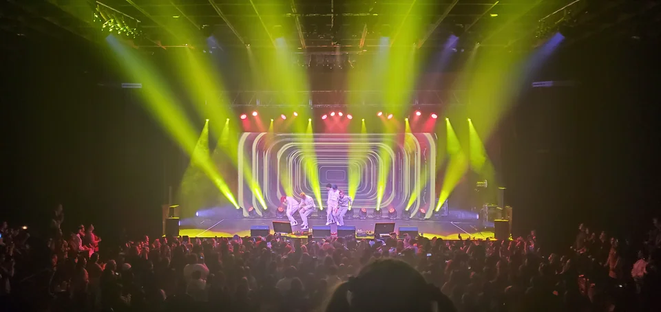 A wide concert view with display content and stage lighting.