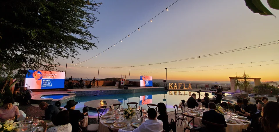 The audience facing the presentation area at sunset.